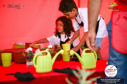 Enfants rempotant des plantes avec des arrosoirs à l'atelier jardinage