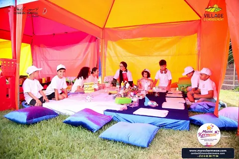 Enfants en atelier créatif sous une tente colorée du Village d'engagement Lesieur Cristal