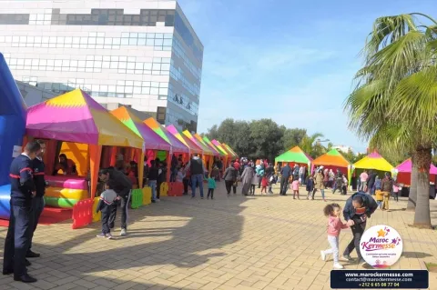 Allée de stands colorés de la kermesse MEDZ Sourcing au parc Casanearshore